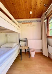 a bedroom with a bed and a chair and a window at B&B Parkgården Leksand in Leksand