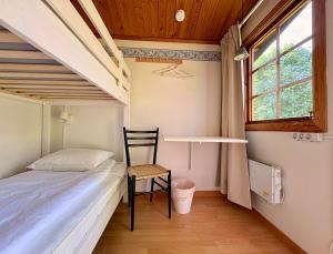 a small bedroom with a bed and a chair at B&B Parkgården Leksand in Leksand