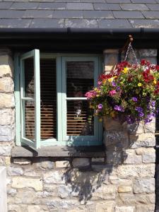 a window with flowers on a stone wall at Moorshead Farm Cottages in Llysworney +5 photos