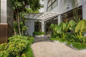 ein Innenhof eines Gebäudes mit Pflanzen und einem Gehweg in der Unterkunft Thadatra INN in Phnom Penh
