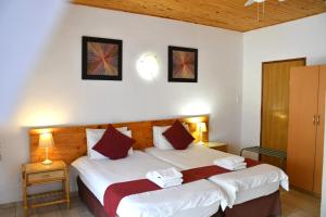 a bedroom with two beds in a room with two lamps at Hotel Uhland in Windhoek +57 photos