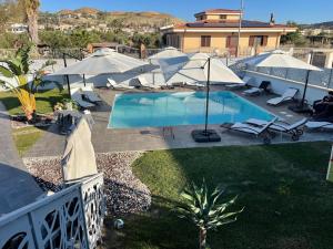 an overhead view of a pool with umbrellas and chairs at Albamaris Guest House in Botricello