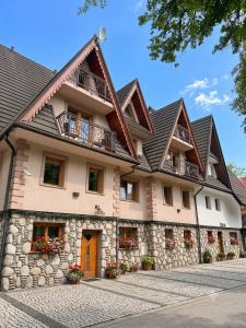 a large building with a stone facade with a roof at Śwarna Wynajem Pokoi in Zakopane