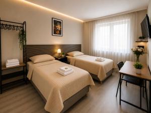 a hotel room with two beds and a television at Modern Living Apartment Hotel in Nuremberg