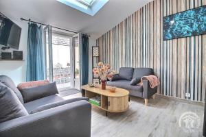 a living room with two couches and a table at L'impasse temps in Saint-Quay-Portrieux