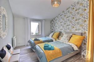 a bedroom with two beds and a wall mural at L'impasse temps in Saint-Quay-Portrieux