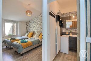 a small bedroom with a bed and a kitchen at L'impasse temps in Saint-Quay-Portrieux