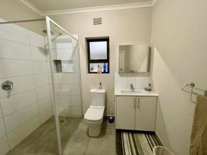 a bathroom with a toilet and a sink and a shower at Beach House on Pachena in Plettenberg Bay +32 photos