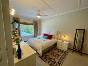 a bedroom with a bed and a dresser and a mirror at Beach House on Pachena in Plettenberg Bay