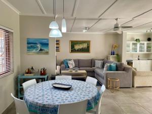 a living room with a table and a couch at Beach House on Pachena in Plettenberg Bay