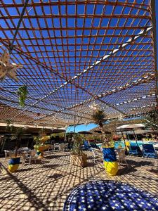 a pavilion with chairs and tables under a roof at Auberge le Refuge in Agadir