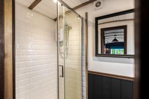 a shower with a glass door in a bathroom at Berry Brook in Oakengrove Vineyard in Fawley