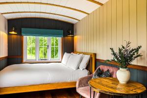a bedroom with a bed and a table and a window at Berry Brook in Oakengrove Vineyard in Fawley