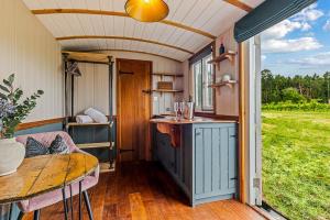 an interior of a tiny house with a kitchen and a table at Berry Brook in Oakengrove Vineyard in Fawley