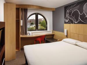 a bedroom with a bed and a desk and a window at ibis Southampton in Southampton +55 photos