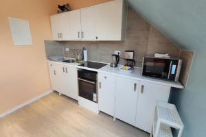 a small kitchen with white cabinets and a microwave at Privilege - Viel inklusiv! in Viersen