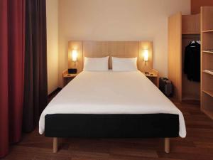 a bedroom with a large white bed with two pillows at ibis Hotel Nürnberg Altstadt in Nuremberg