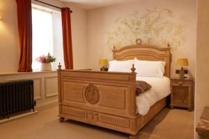 a bedroom with a wooden bed and a window at The Dirty Habit in Hollingbourne
