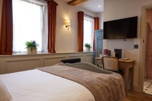 a hotel room with a bed and a flat screen tv at The Dirty Habit in Hollingbourne