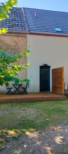 a white building with a black door and a porch at calme et volupté in Maxilly-sur-Saône