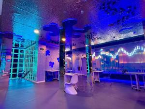 a room with tables and chairs and purple lights at The POD Suite Hostel Joaquin Sorolla in Valencia