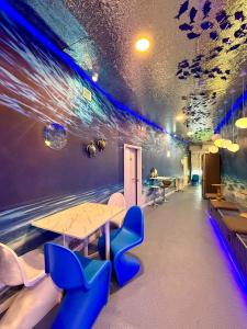 a room with a table and some blue chairs at The POD Suite Hostel Joaquin Sorolla in Valencia