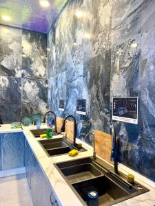 a kitchen with two sinks and a stone wall at The POD Suite Hostel Joaquin Sorolla in Valencia +37 photos