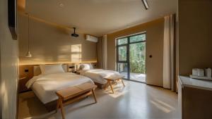 a bedroom with two beds and a window at Qinxiang Pavilion Hotel in Dunhuang +45 photos