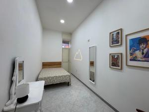 a white room with a bed and a desk and a bedroom at B&B Napul'è in Naples
