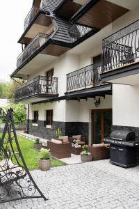 an outdoor patio with a grill and a building at Willa Lasak - 20 procent zniżki na Termy, Śniadania in Biały Dunajec