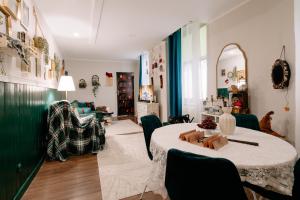 a living room with a table and a couch at Magiczny Salonik Harrego - Magical Old Town Apartment in Toruń