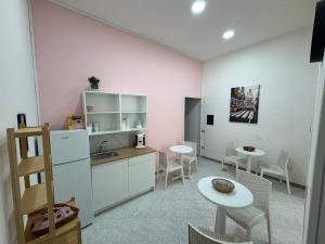 a kitchen with white cabinets and a table and chairs at B&B Napul'è in Naples