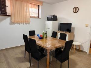 a dining room with a table and chairs and a refrigerator at Apartments Silvana 1183 in Banjole