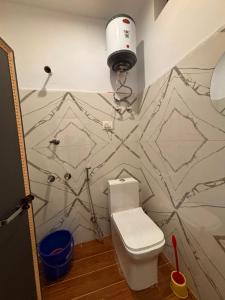 a bathroom with a toilet and a wall at Hotel Anushka palace in Phata