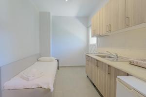 a kitchen with a bench in the middle of it at Salty Sea View Apartments in Polychrono +29 photos