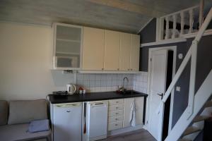 a small kitchen with white cabinets and a sink at Sjöstugan in Tyresö
