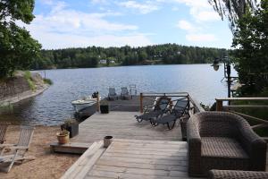 a dock with benches and a boat on a lake at Sjöstugan in Tyresö +8 photos