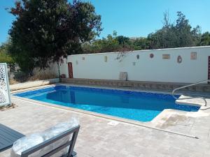 a swimming pool in front of a white wall at Empa Residence with private pool in Emba +29 photos