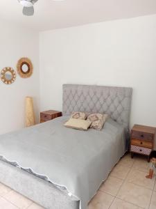 a bedroom with a bed with a gray headboard at Empa Residence with private pool in Emba