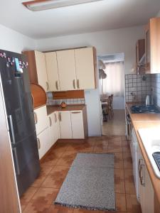 a kitchen with white cabinets and a black refrigerator at Empa Residence with private pool in Emba