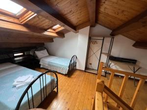 ein Dachzimmer mit zwei Betten und Holzboden in der Unterkunft Casa DeviDanza in Lago
