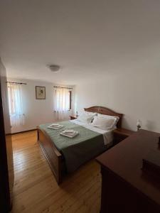 ein Schlafzimmer mit einem Bett mit grünen Laken und weißen Kissen in der Unterkunft Casa DeviDanza in Lago