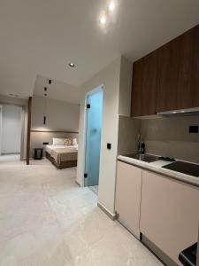 a kitchen with a sink and a bed in a room at Villa Hara Suites in Paralia Katerinis