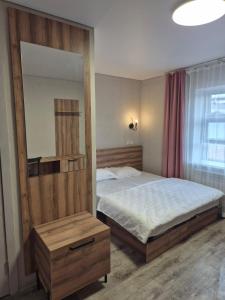 a bedroom with a bed and a large mirror at Qonaq Hostel in Astana