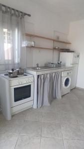 a kitchen with a stove and a washing machine at evgenias studio 2 in Gaios