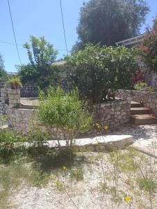 a stone retaining wall with stairs and a garden at evgenias studio 2 in Gaios