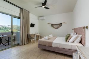 a bedroom with a bed and a sliding glass door at Kassiani Studios Olive Groove hotel in Plakias
