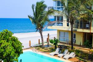 a hotel with a swimming pool next to the beach at Brisa Marina Beach Resort powered by Cocotel in Morong