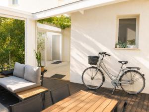 a bike parked on a patio with a couch and a table at Amare Suite & Apartments in Bellaria-Igea Marina