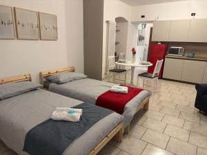 two beds in a room with a kitchen and a table at In Bottega Apt 1 in Bosisio Parini